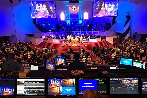 A conference auditorium with a live production feed