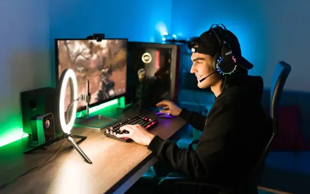 A streamer at a gaming desk with a ring light and headset
