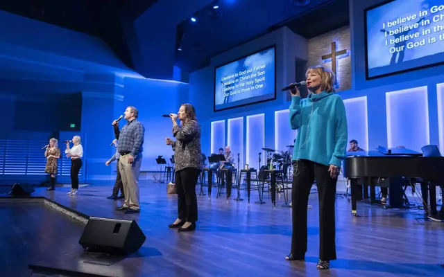 A worship team singing on a lit stage